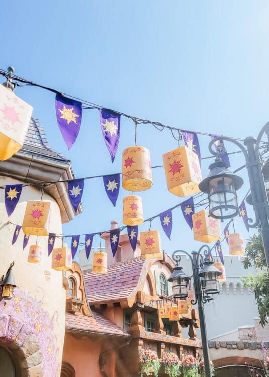 Looking up to Tangled flags and lanterns hung between buildings