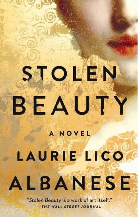 Book cover for Stolen Beauty by Laurie Lico Albanese, featuring a partial image of a woman's painted face with red lips set against a gold textured background with swirling patterns. Bold black text includes the title, author’s name, and a quote from The Wall Street Journal praising the novel.