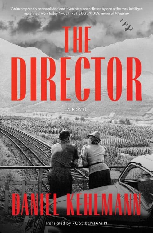 Cover of The Director, a novel by Daniel Kehlmann, translated by Ross Benjamin, featuring a black-and-white photo of a man and woman leaning on a railing overlooking train tracks and farmland. Red title text dominates the center, with warplanes flying in formation above distant mountains and a quote from Jeffrey Eugenides at the top.