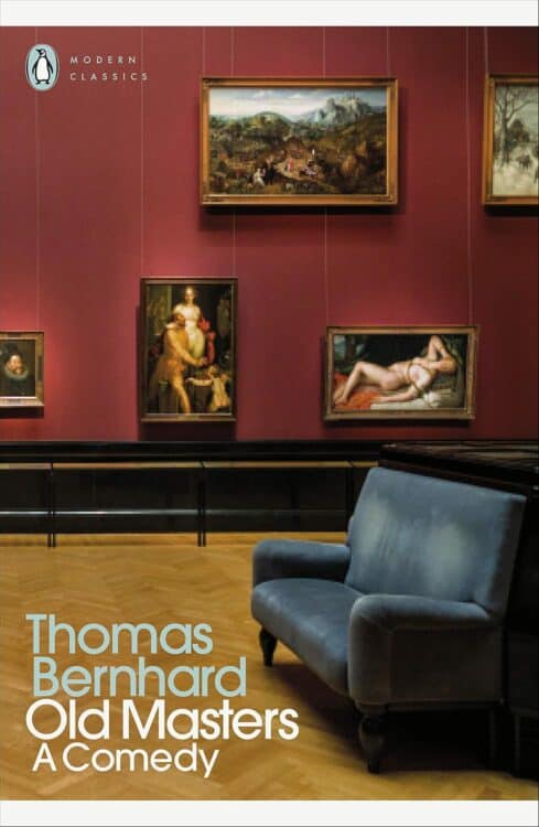 Cover of Old Masters: A Comedy by Thomas Bernhard, part of the Penguin Modern Classics series. The image shows a red-walled art gallery with classical paintings, including reclining nude figures and historical scenes, with a blue velvet bench in the foreground on a polished parquet floor. The setting suggests themes of art, critique, and observation.