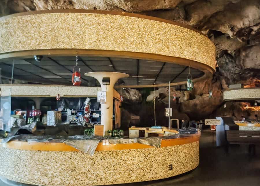 A circular snack bar built into the cave walls at Carlsbad Caverns features stone counters and hanging lantern-style lights. The underground dining area offers a unique stop along a Carlsbad Caverns itinerary.